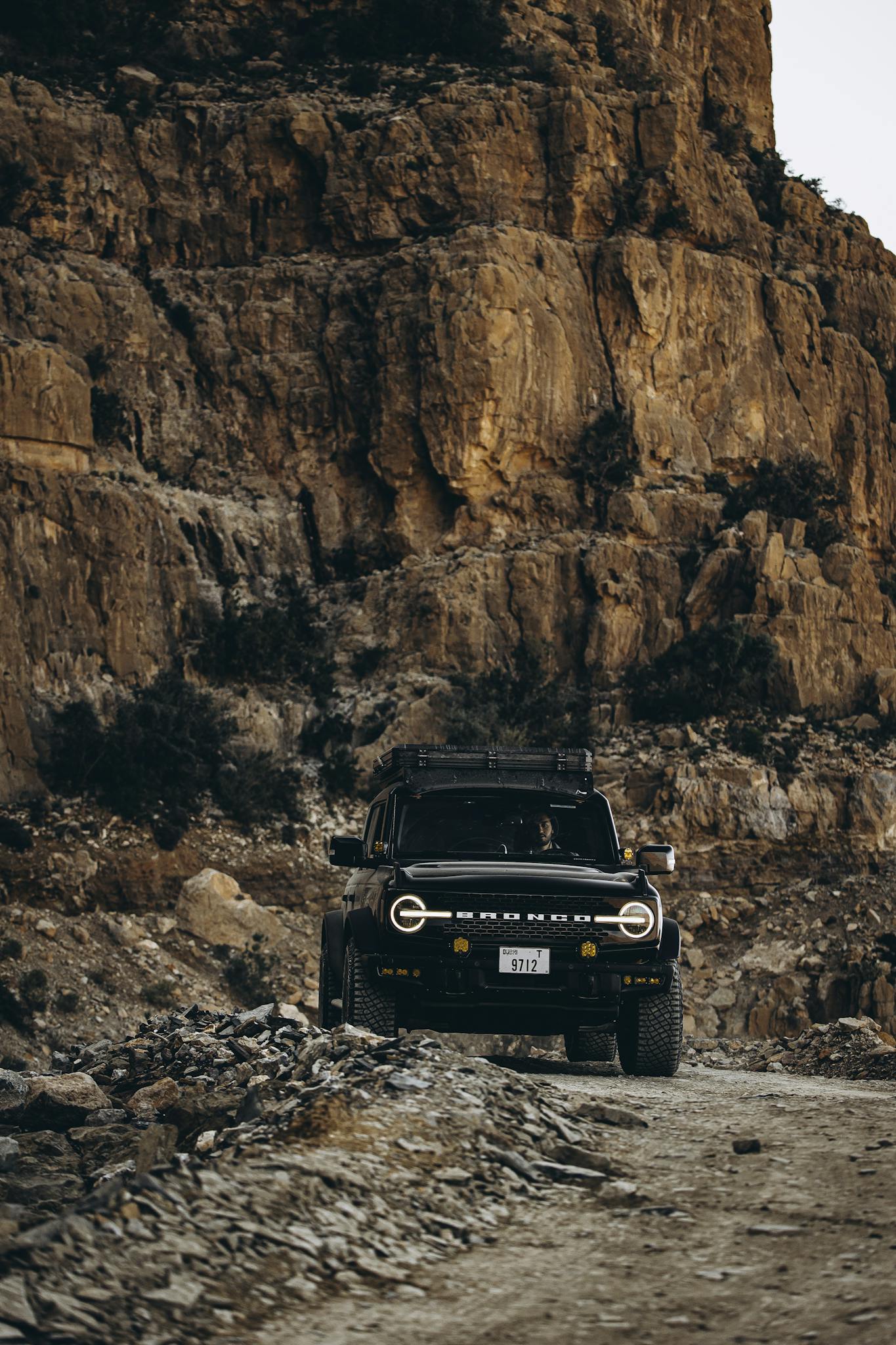 A rugged offroad vehicle navigates the rocky landscapes of Oman, showcasing adventure and travel.